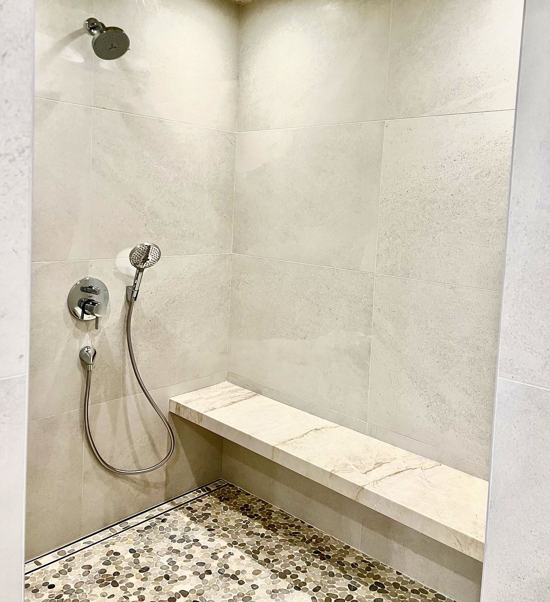Shower with pebble floor and stone bench