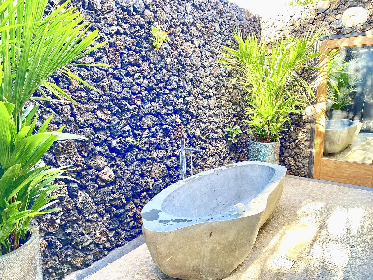 Stone tub against lava rock wall